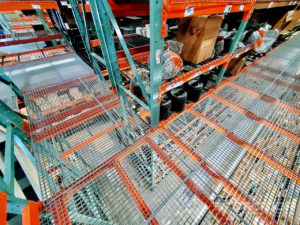 Photo taken from second level of pallet rack supported mezzanine showing the bar grating flooring